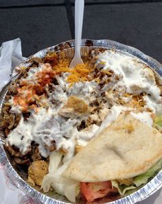 a taco salad with meat, cheese and tortilla bread in a foil container