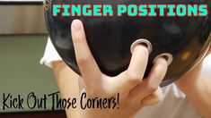 a person holding up a black ball with the words finger positions on it and two fingers in front of their face