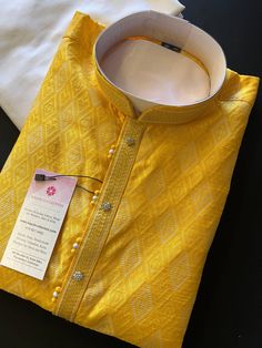 Premium quality Yellow Color Silk Men's Kurta Pajama Set with design pattern all over the Kurta. The neckline has lace work and fancy buttons. Item : Men's Kurta PajamaReady to Wear : YesPocket : YesKurta Color : Yellow Pajama Color : Cream/White Fabric : SilkLining : Yes Work : Fancy buttons, Woven Zari work, Lace WorkPattern : DesignerDisclaimer-For sizing please refer to the Size Chart given in the listing with the pictures.- Please do NOT go by the size of the Kurta that you already have fro Yellow Kurta Pajama Men, Haldi Dress For Men Yellow, Fitted Cotton Sherwani With Traditional Patterns, Yellow Fitted Cotton Sherwani, Yellow Cotton Bollywood Sherwani, Bollywood Style Yellow Cotton Sherwani, Yellow Kurta Men For Haldi, Yellow Kurta Men, Haldi Function Dress