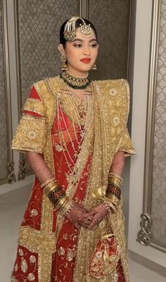 a woman in a red and gold wedding outfit