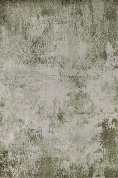 an old, worn and stained area rug with faded paint on the edges in shades of green