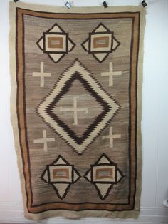 an old rug is hanging on the wall