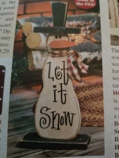 a wooden snowman ornament with the words let it snow