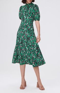 Make an enchanting impression at any occasion in this crepe midi dress awash in a bold print and framed by puff sleeves and a mock neck. Hidden back-zip closure Mock neck Elbow-length sleeves 100% polyester Dry clean Imported Elegant Printed Green Midi Dress, Elegant Green Printed Midi Dress, Green Puff Sleeve Midi Dress With Floral Print, Green Floral Print Midi Dress With Puff Sleeves, Formal Floral Print Midi Dress With Puff Sleeves, Green Midi-length Puff Sleeve Dress With Gathered Sleeves, Green Midi Puff Sleeve Dress With Gathered Sleeves, Green Midi Length Puff Sleeve Dress With Gathered Sleeves, Printed Knee-length Midi Dress For Work