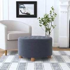 a living room with two chairs and a round footstool in front of a fireplace