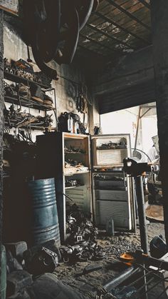 an old kitchen with lots of clutter on the floor and shelves full of tools