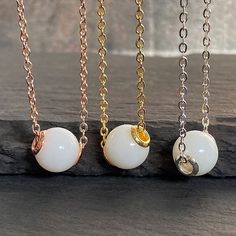 "Breastmilk pearl necklace with sterling silver cores, gold plated. Pearl effect can be added.  Our \"My Sweet Little One\" necklace transforms your breast milk into a beautiful keepsake 9 mm \"pearl\" pendant on a 20-inch flat cable chain. Add in pearl powder for a real pearlescent look. Sterling silver cores with yellow or rose gold plating options.  For all our breast milk pearl collection, please visit: https://www.etsy.com/ca/shop/KeepsakeMom?ref=seller-platform-mcnav&section_id=36089680 Fo White Pearl Pendant Jewelry, Handmade White Pearl Charm Necklaces, White Pearl Charm Necklace With Pearl Drop, White Charm Necklace With Pearl And Round Beads, White Pearl Charm Necklace With Round Beads, White Pearl Charm Necklace With Pearl Chain, White Pearl Drop Charm Necklace, White Pearl Chain Charm Necklaces, White Pearl Charm Pendant Necklace