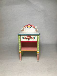 a small wooden table with an ornate design on it's top and bottom shelf