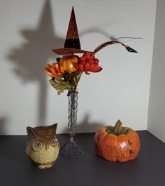 two pumpkins and an owl are sitting on a table