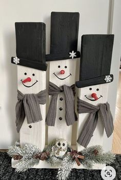 three snowmen with hats and scarfs on their heads