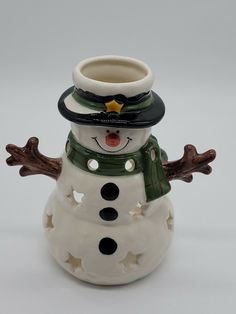 a ceramic snowman is wearing a hat and scarf