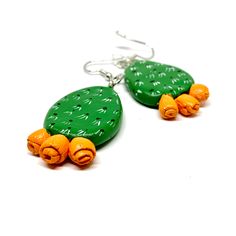 two green and orange earrings sitting on top of each other