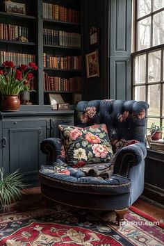 a blue chair sitting on top of a rug in front of a book shelf filled with books