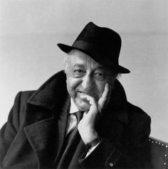 black and white photograph of an old man wearing a hat with his hand on his chin