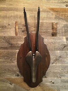 a wooden clock with two black sticks sticking out of it's face on a wall