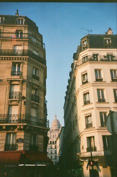 some very tall buildings with balconies in the windows and one building on the other side