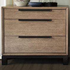 a wooden dresser with two drawers and a vase on top