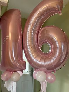 the number six is made out of pink and white balloons with streamers hanging from them