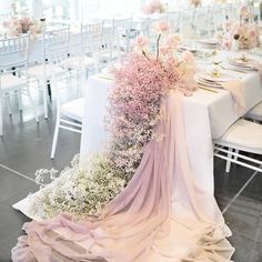 the table is set with white and pink flowers