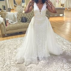 a woman in a white wedding dress posing for the camera with her hand on her head