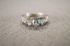 I am offering you this vintage sterling silver  wedding band stacker design ring. It features 3  total oval shaped prong set genuine faceted blue topaz stones.  These stones are set in a raised relief multi stone setting. There is fabulous raised relief design work here. It is measuring app. 3/4 inch, by app. 1/4 inch.  It is currently a size, 6.5 .   Though  I am sure it could be sized up or down. It weighs app. 5 grams.  Look at the detail of the design work of this vintage ring Simply breatht Aquamarine Three-stone Wedding Rings, Aquamarine Three Stone Wedding Rings, Wedding Topaz Three Stone Ring, Wedding Blue Topaz Three Stone Ring, Three Stone Blue Topaz Jewelry For Wedding, Sterling Silver Three Stone Topaz Wedding Ring, Sterling Silver Topaz Three Stone Wedding Ring, Sterling Silver Three Stone Topaz Ring For Wedding, Classic Three-stone Topaz Ring For Wedding