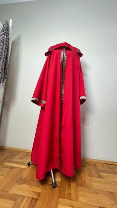 a red raincoat is on display in a room with wood floors and white walls