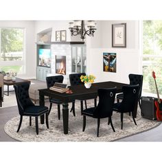 a dining room table with black chairs and a guitar on the rug in front of it