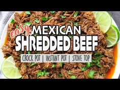 mexican shredded beef on a plate with limes and cilantro garnish