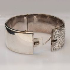 ...ORIGINAL PRICE $1350.00 Now $850.00...Just like the flowers decorate the rose gardens of England, engraved flowers and vines decorate this gorgeous antique English bangle bracelet.  Crafted from sterling silver, this 1920's bracelet is a dainty yet sturdy piece of history.  Signed by Birks, and made in England, this bangle has a push button clasp and a safety chain for added security.  What a wonderful addition for your jewelry collection.Antique Bracelet1920'sSigned Birks Made in EnglandSter Classic Engraved Bangle For Ceremonial Occasions, Classic Ceremonial Engraved Bangle, Victorian White Gold Bracelets For Formal Occasions, Victorian Style White Gold Bracelets For Formal Occasions, Classic Cuff Bracelet With Intricate Design For Anniversary, Luxury Engraved Bracelets For Ceremonial Occasions, Elegant Engraved Bracelet For Formal Occasions, Antique Formal Bracelets With Box Clasp, Classic Ceremonial Hallmarked Bracelets