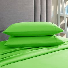 two lime green pillows sitting on top of a bed