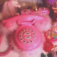 a pink phone sitting on top of a table next to other toys