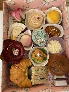 an open box filled with different types of pastries and desserts on top of each other