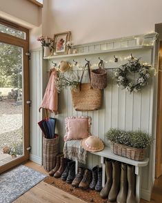 an entryway with boots, umbrellas and baskets hanging on the wall next to it