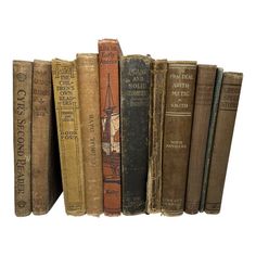 several old books are lined up in a row on a white background, with one book open and the other closed