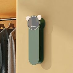 a bear shaped object is mounted on the wall next to a coat rack and clothes