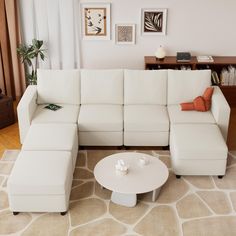 a living room with a white sectional couch and coffee table