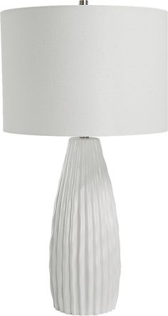 a white table lamp with a pleated shade on the base and a light bulb