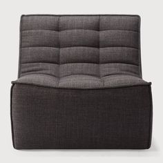 a gray chair with buttons on the armrests and a black seat cushion in front of it