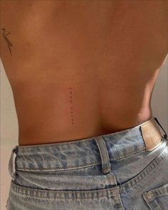 the back of a woman's stomach with an arrow tattoo on her left side