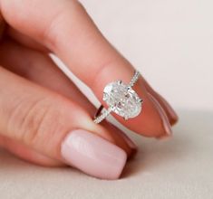 a woman's hand with a ring on her finger and a diamond in the middle