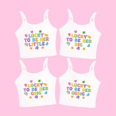 four white crop tops with lucky to be big written on the front and rainbow letters across the chest