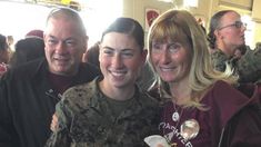 two women and one man are smiling for the camera