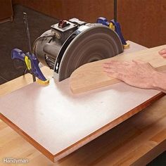 a man is using a circular saw to cut plywood planks on a workbench