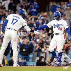 two baseball players are shaking hands on the field