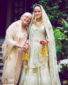 two women dressed in wedding attire posing for a photo on the instagram page, with one holding her arm around the other's shoulder