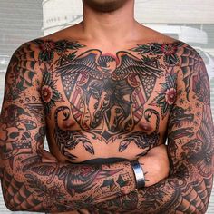 a man with tattoos on his chest and arms