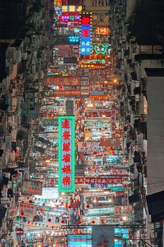 an aerial view of a city at night with lots of lights and signs on the buildings