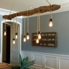 the light bulbs are hanging from the wood beam in the dining room area, which is decorated with driftwood planks