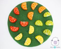 a green felt plate with oranges and lemons on it, in the shape of a circle