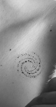 the back of a woman's shoulder with dots and circles on her left side